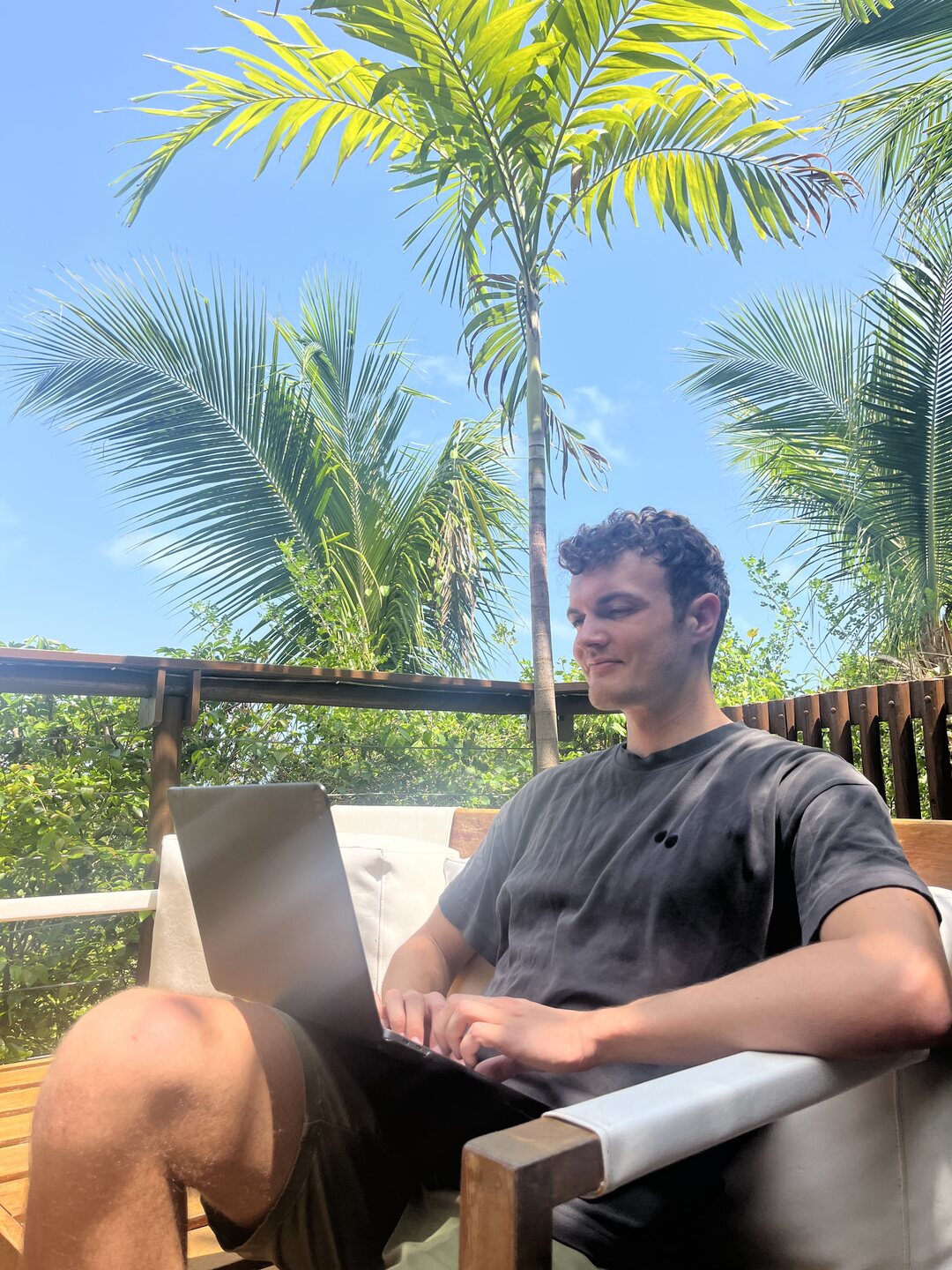 Daniel Lösch working remotely under palm trees